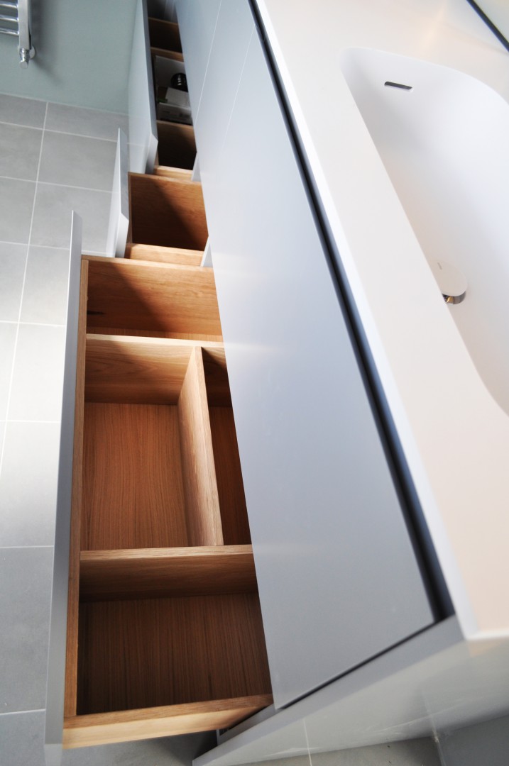 Bagno realizzato su misura. Sportelli in finitura laccata, top in corian, specchi retroilluminati da LED. Cassetti interni in rovere massiccio con finitura naturale Biologica.