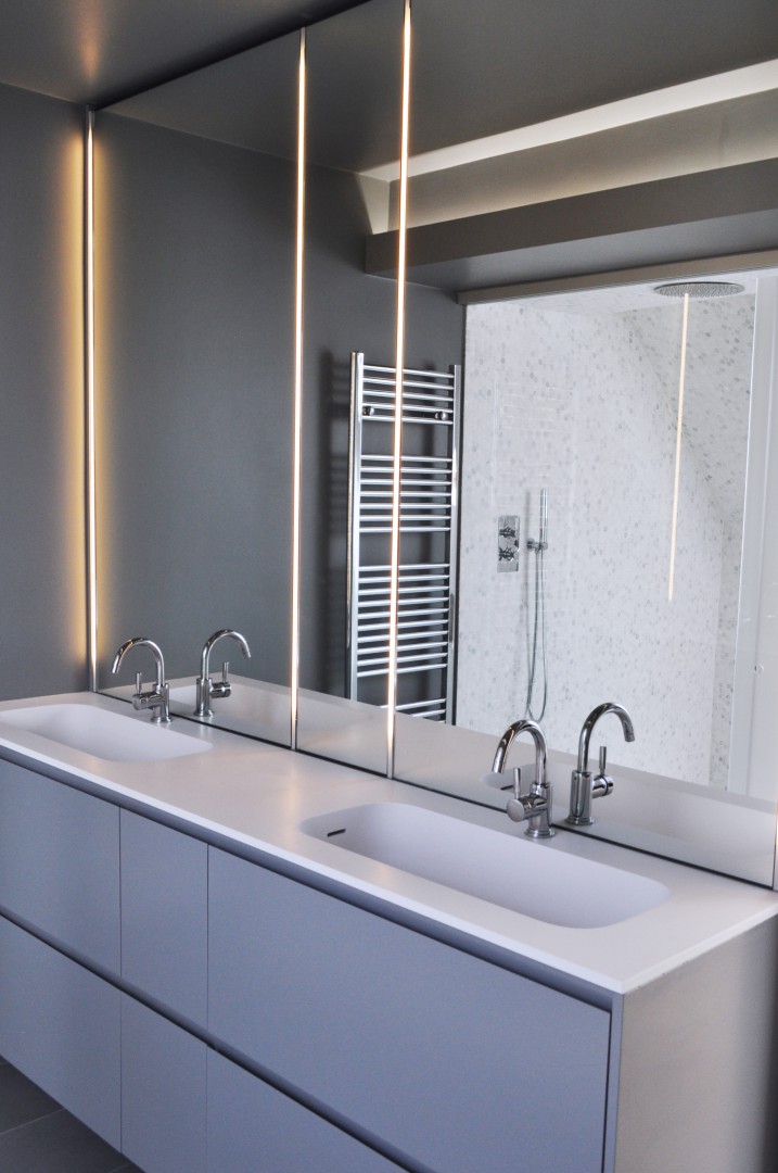 Bagno realizzato su misura. Sportelli in finitura laccata, top in corian, specchi retroilluminati da LED. Cassetti interni in rovere massiccio con finitura naturale Biologica.