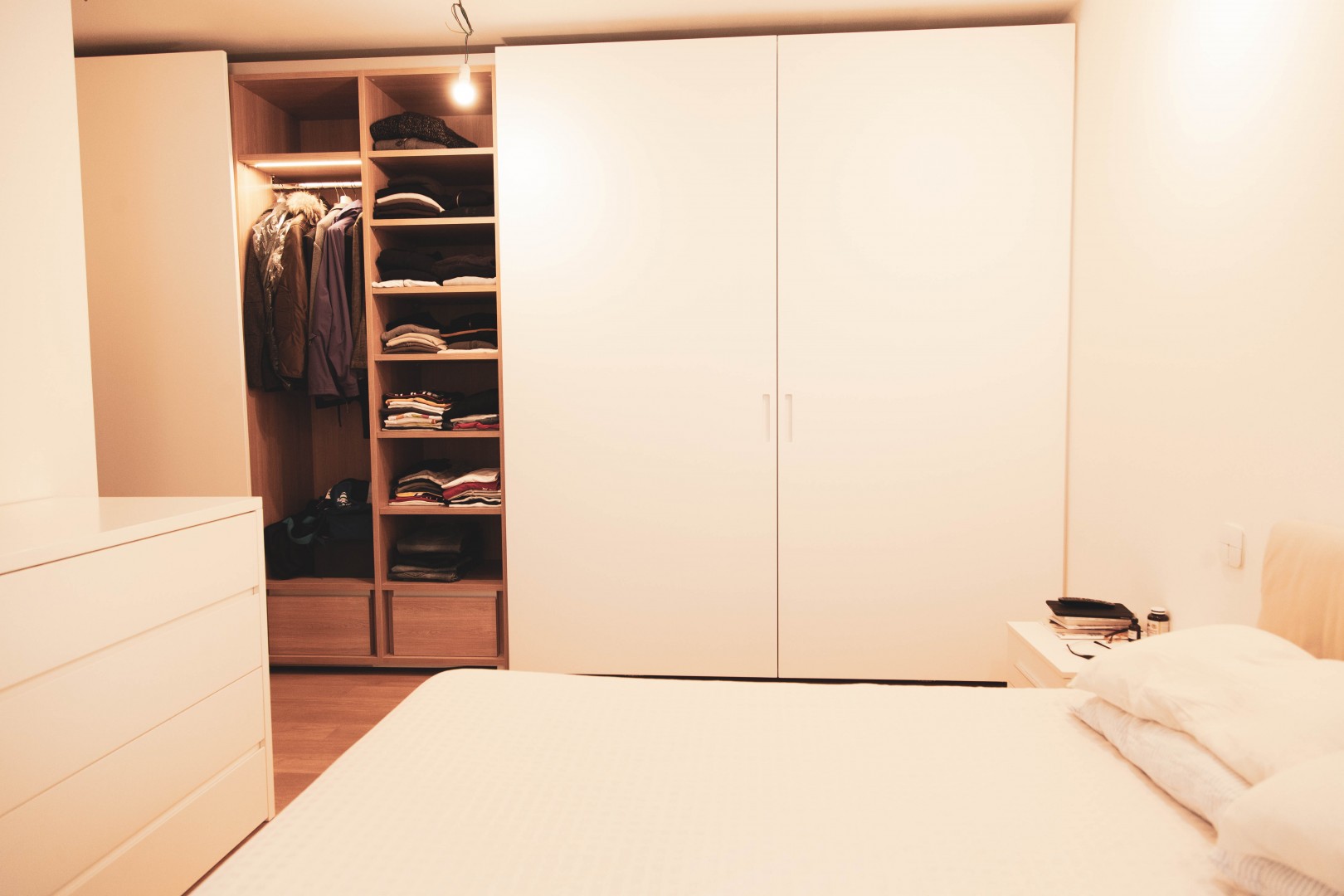 Arredamento su misura realizzato da Profili - Falegnameria & Design. Armadio su misura per camera da letto. Interni in legno rovere e ante laccate. Ante complanari.