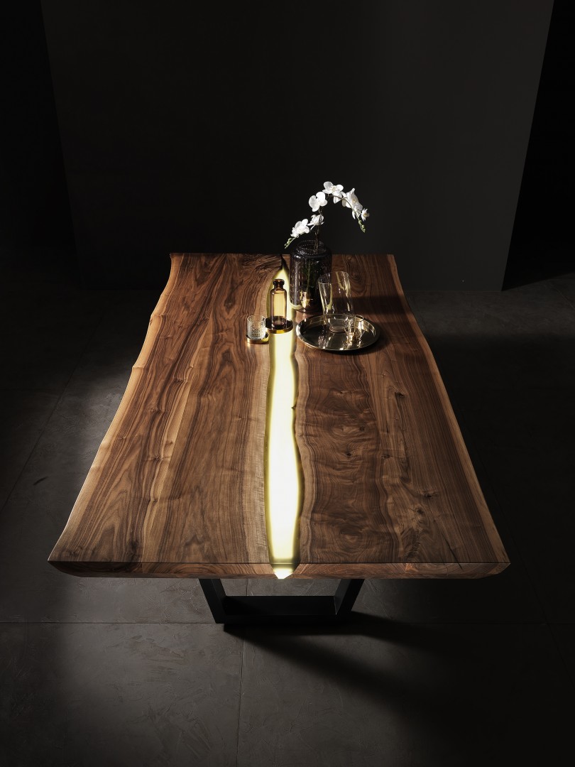 Tavolo di lusso di design disegnato da Francesco Profili. Il tavolo è composto da due tavole di Noce Canaletto divise da una resinata retroilluminata. Questo tavolo è un pezzo di alto design made in Italy.